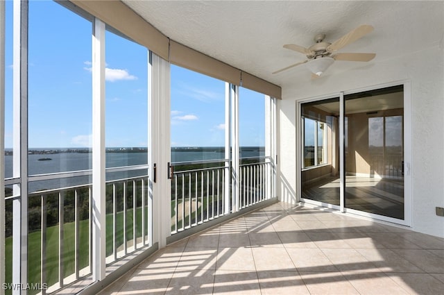 unfurnished sunroom with a water view and ceiling fan