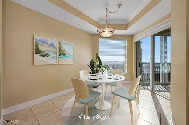 dining space featuring a raised ceiling, light tile patterned flooring, baseboards, and ornamental molding