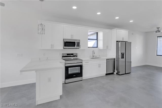 kitchen with appliances with stainless steel finishes, white cabinetry, hanging light fixtures, and sink