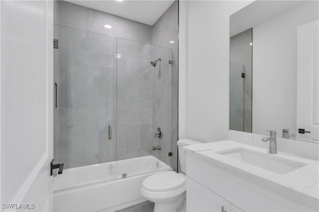 full bathroom featuring toilet, enclosed tub / shower combo, and vanity