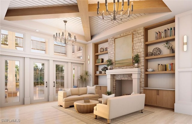 interior space with french doors, built in shelves, a notable chandelier, a fireplace, and light hardwood / wood-style floors