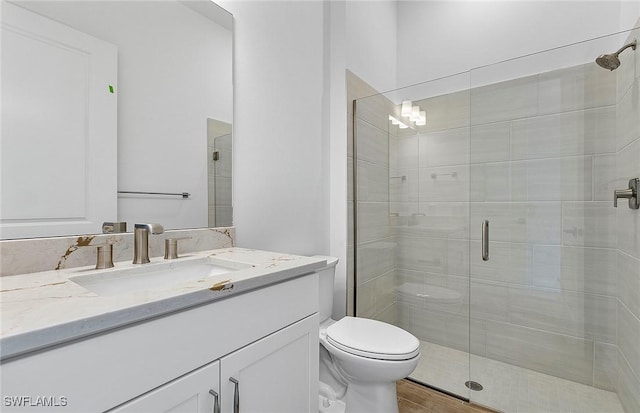 bathroom with hardwood / wood-style floors, vanity, a shower with shower door, and toilet