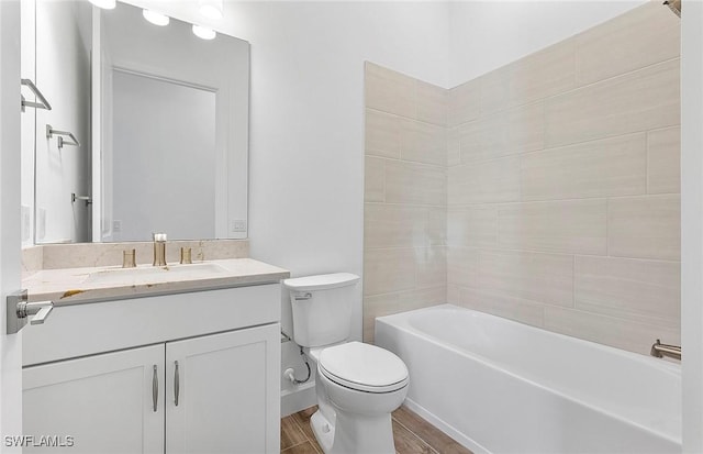 full bathroom with vanity, tiled shower / bath combo, and toilet