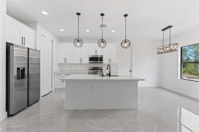 kitchen featuring white cabinets, an island with sink, stainless steel appliances, and sink