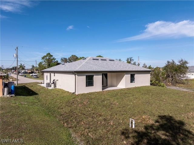 view of side of property with a yard, cooling unit, and a patio area