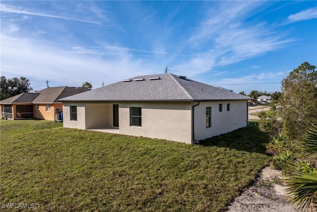 back of property featuring a lawn and a patio