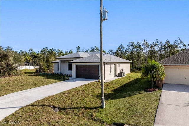 view of front of home with central air condition unit, a front lawn, and a garage