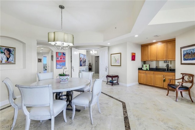 dining area featuring sink and a chandelier