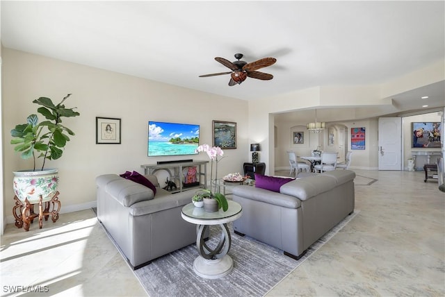 living room with ceiling fan with notable chandelier