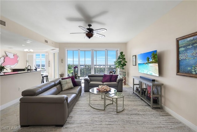 living room with a wealth of natural light, ceiling fan, and light tile patterned flooring