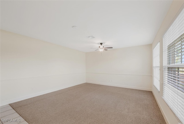 carpeted spare room with ceiling fan