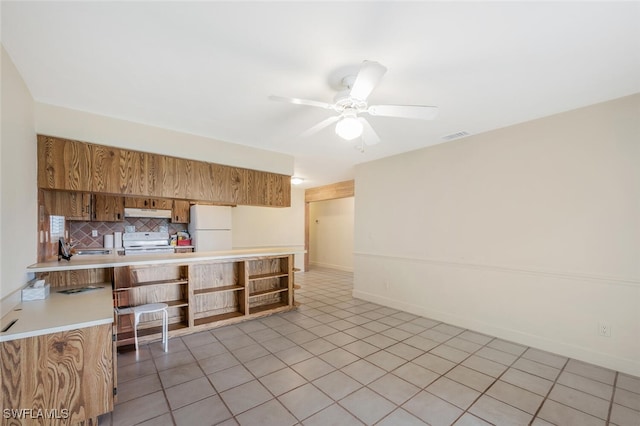 kitchen with white appliances, ceiling fan, light tile patterned floors, tasteful backsplash, and kitchen peninsula