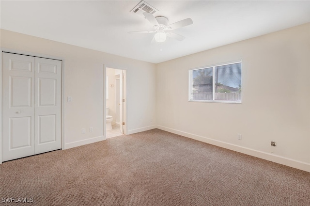 unfurnished bedroom with carpet floors, a closet, ceiling fan, and connected bathroom