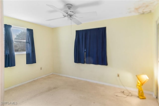 carpeted spare room with ceiling fan