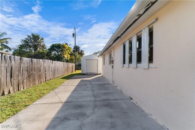 view of side of home featuring a patio area and a storage unit