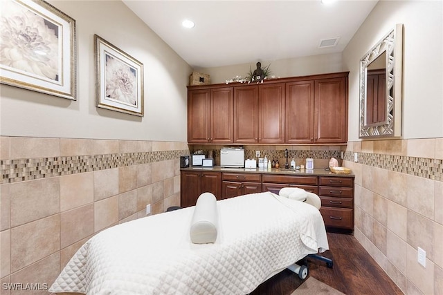 bedroom featuring sink, dark hardwood / wood-style flooring, and tile walls