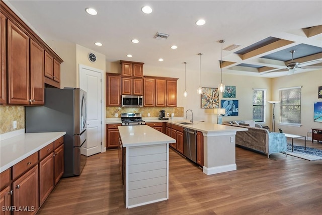 kitchen with kitchen peninsula, appliances with stainless steel finishes, coffered ceiling, dark wood-type flooring, and decorative light fixtures