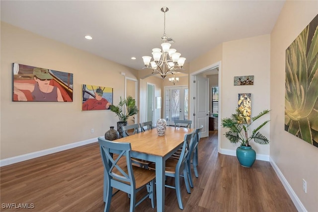 dining room with a notable chandelier and dark hardwood / wood-style flooring