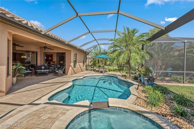 view of pool with an outdoor living space, glass enclosure, ceiling fan, an in ground hot tub, and a patio