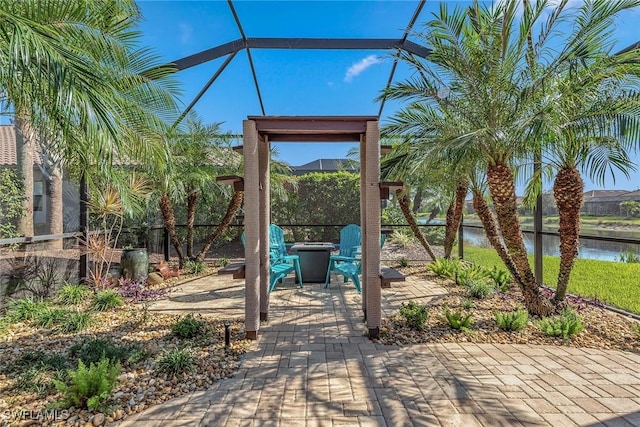 view of patio with a water view and a lanai