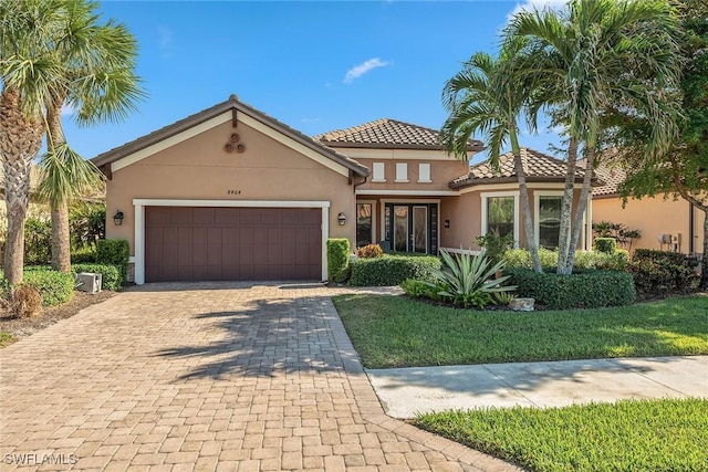8464 Palacio Ter W, Naples, FL 34114 - view of front of property with an attached garage, stucco siding, driveway, and a tile roof