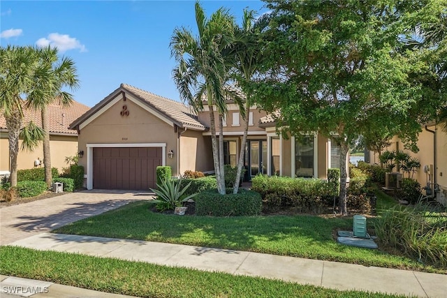 8464 Palacio Ter W, Naples, FL 34114 - view of front of property featuring driveway, a garage, stucco siding, a tiled roof, and a front yard