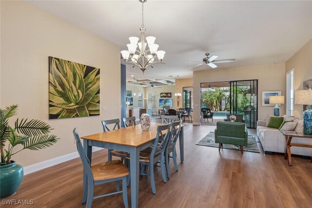 8464 Palacio Ter W, Naples, FL 34114 - dining room featuring a ceiling fan, wood finished floors, baseboards, and a chandelier