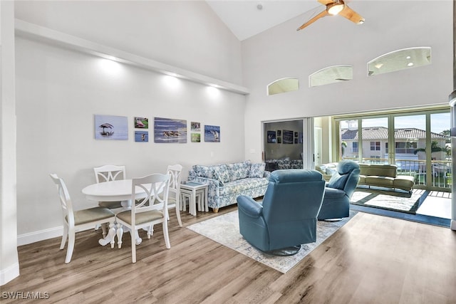 living room featuring high vaulted ceiling, ceiling fan, and light hardwood / wood-style floors