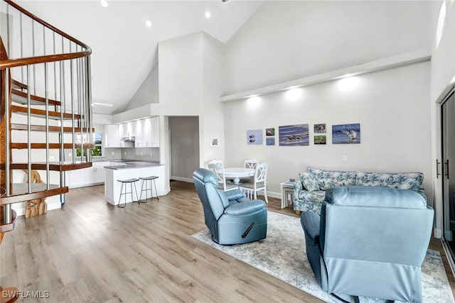 living room with high vaulted ceiling and light hardwood / wood-style floors