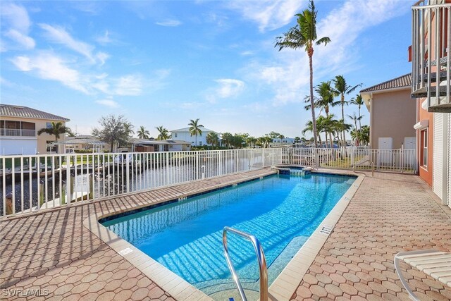 view of pool featuring a hot tub and a water view