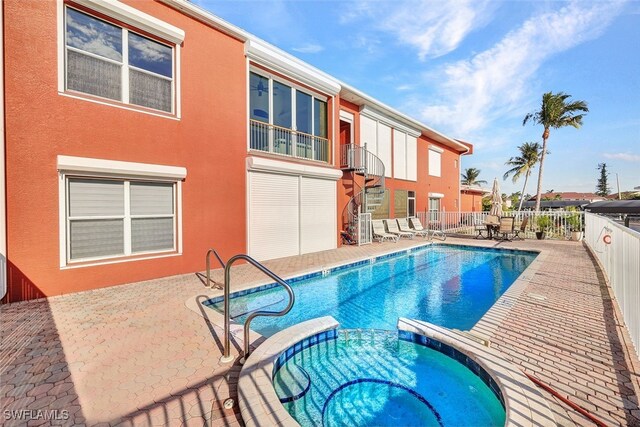 view of swimming pool featuring a patio area and an in ground hot tub