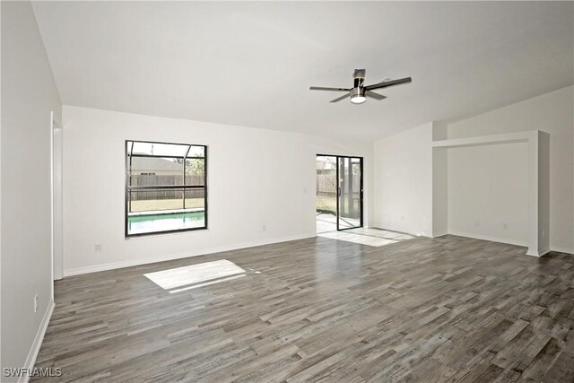 empty room featuring lofted ceiling, ceiling fan, and dark hardwood / wood-style floors