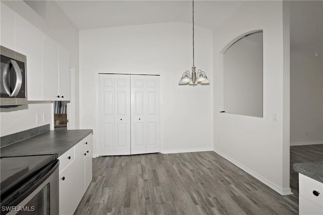 kitchen with white cabinets, decorative light fixtures, lofted ceiling, and black / electric stove