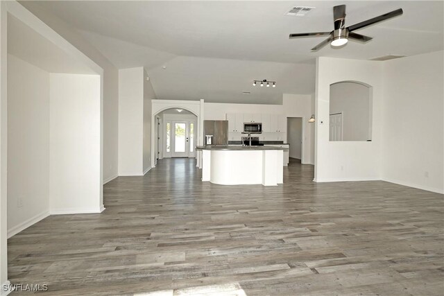 unfurnished living room featuring light hardwood / wood-style floors, vaulted ceiling, and ceiling fan