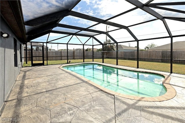 view of swimming pool featuring a patio, a lanai, and a lawn