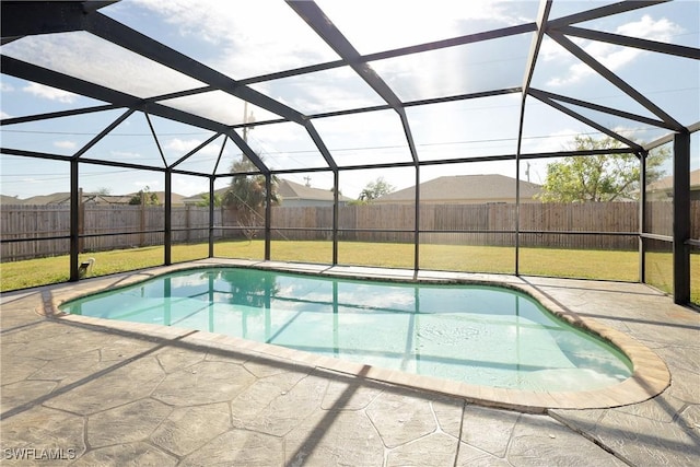 view of pool with a lawn, glass enclosure, and a patio