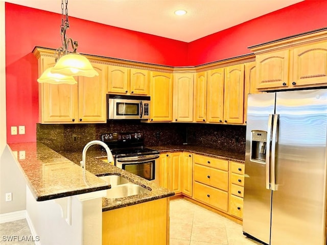 kitchen featuring kitchen peninsula, appliances with stainless steel finishes, tasteful backsplash, dark stone counters, and hanging light fixtures