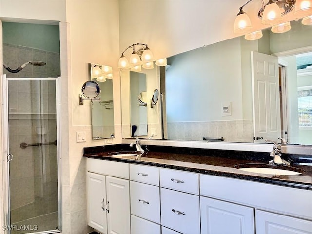 bathroom with vanity, an enclosed shower, and tile walls