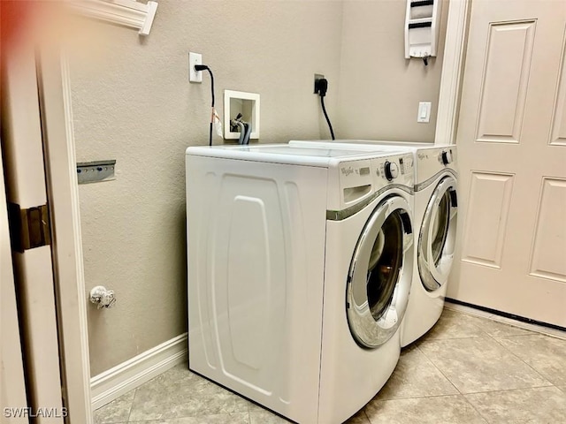 laundry area featuring washer and clothes dryer and light tile patterned floors