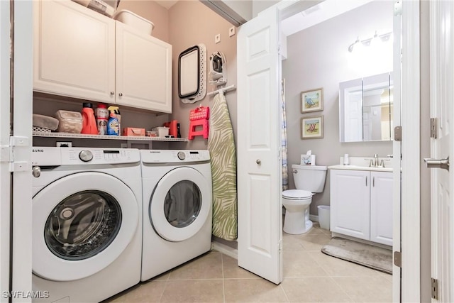 washroom featuring cabinets, washing machine and dryer, light tile patterned floors, and sink