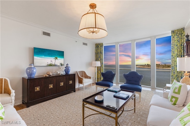 living area featuring a wall of windows, wood finished floors, visible vents, baseboards, and crown molding