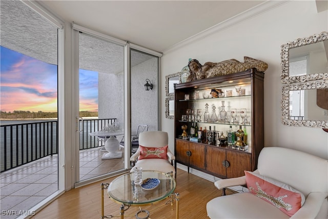 living area featuring ornamental molding, wood finished floors, and expansive windows