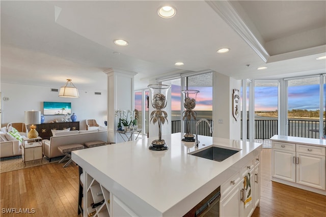 kitchen featuring recessed lighting, white cabinetry, light wood-style floors, and a sink