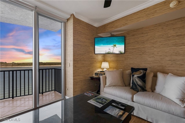 living room featuring tile patterned floors, expansive windows, crown molding, and a water view