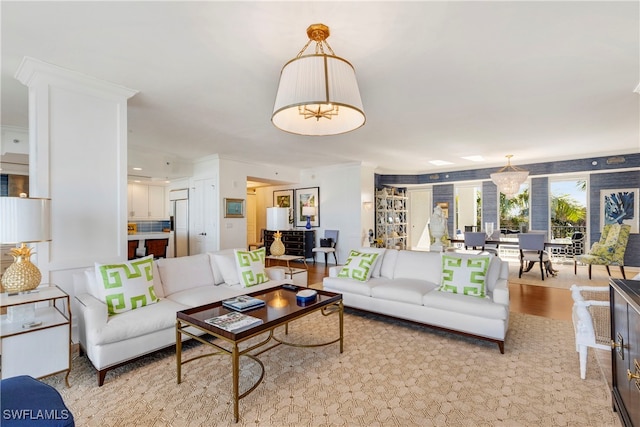 living room featuring a chandelier, crown molding, and wood finished floors