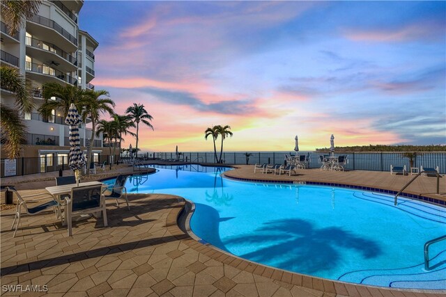 pool at dusk with a patio