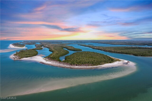 aerial view at dusk featuring a water view