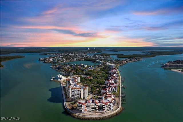 aerial view at dusk featuring a water view