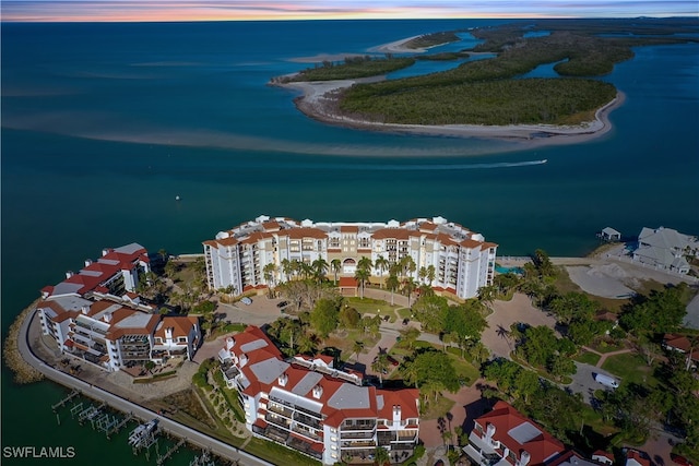 aerial view at dusk featuring a water view