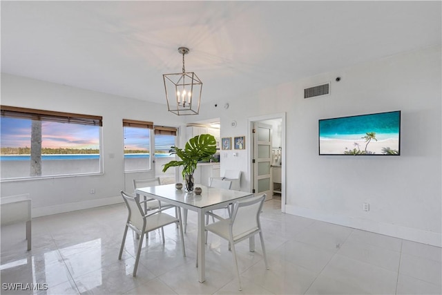 dining area with visible vents, an inviting chandelier, baseboards, and a water view